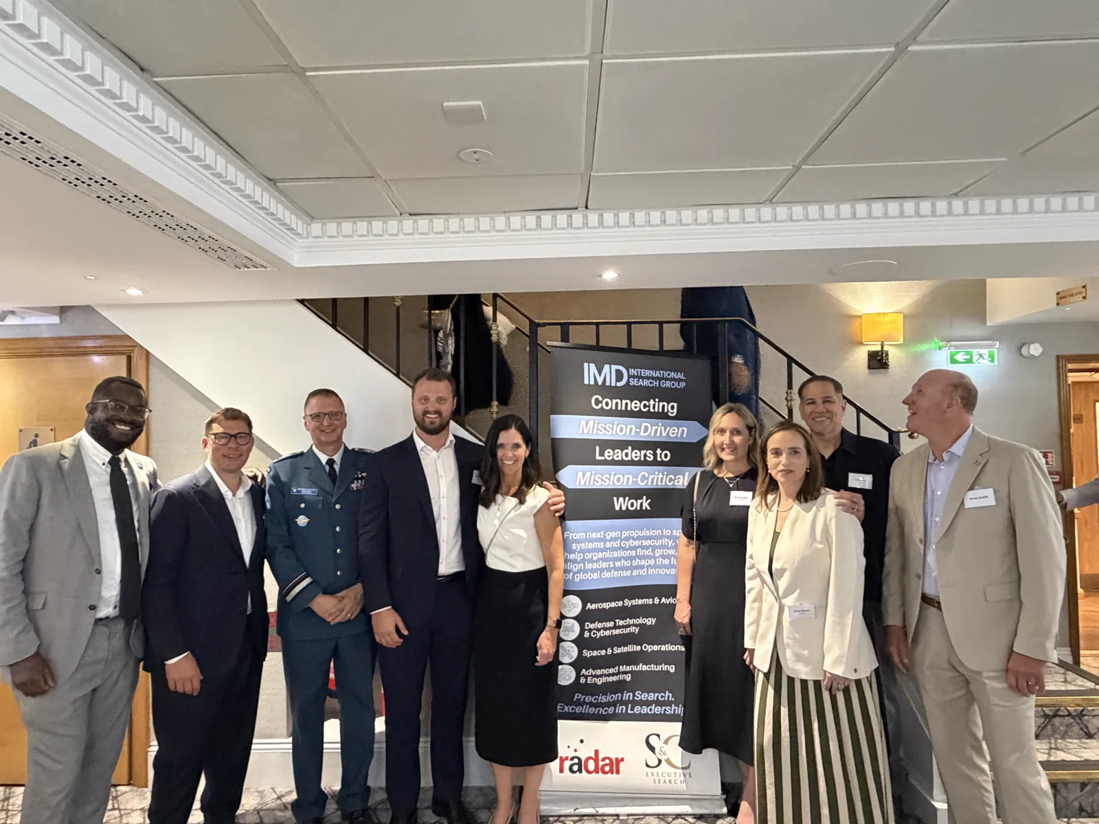 Jose J. Ruiz with IMD International Search Group Aerospace Practice partners in front of the IMD banner — Connecting Mission-Driven Leaders to Mission-Critical Work — at the Farnborough International Airshow, Day 3, 22 July 2026.